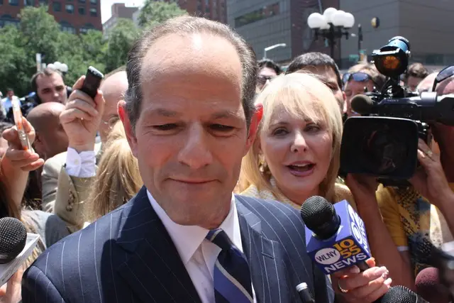 Spitzer, with WCBS 2 reporter Marcia Kramer on his back